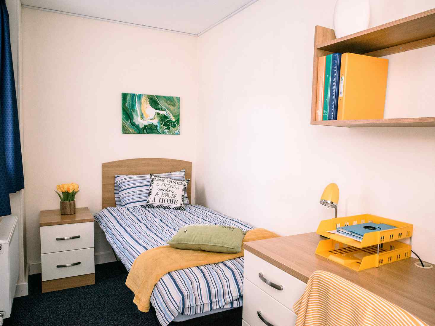 View of Garden Street room, with a single bed, drawers, desk and shelving. 