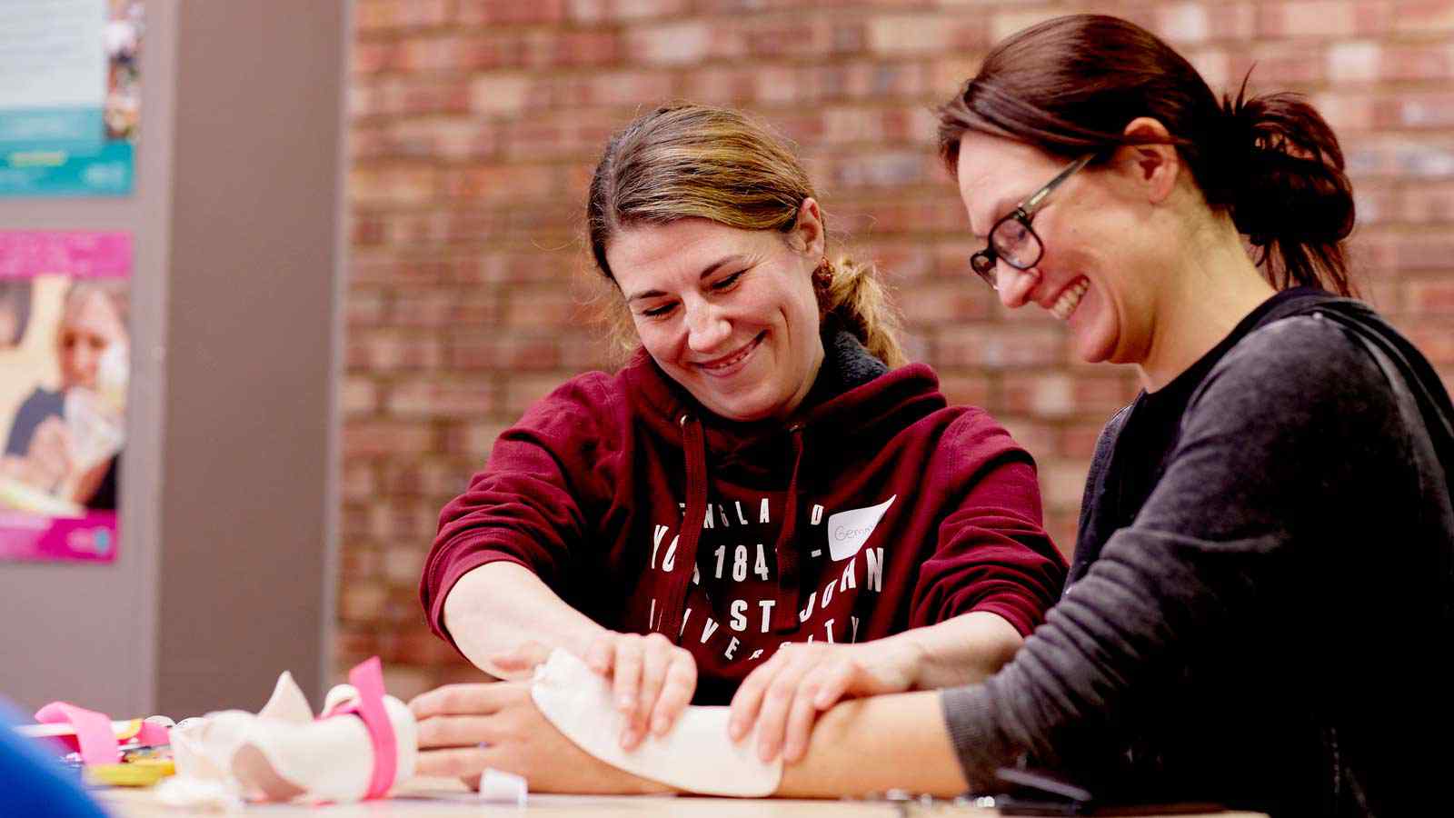 Two occupational therapy students work together in class. 