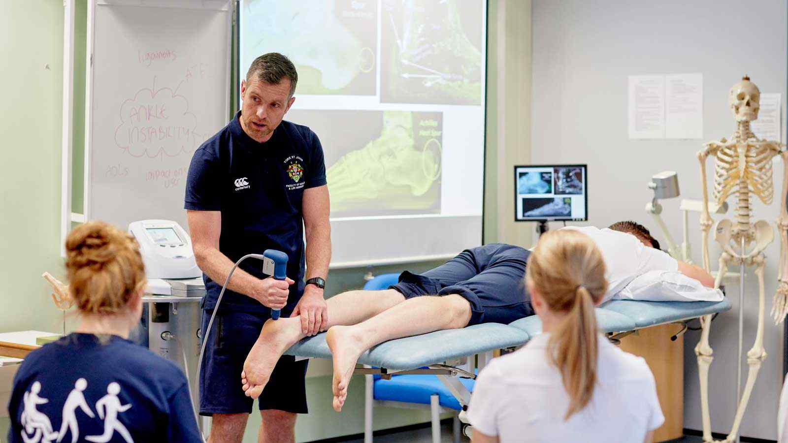 Students watch a physical therapy demo. 