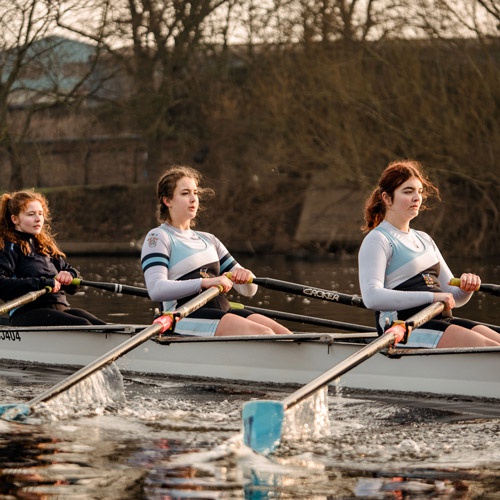 Students rowing on river 