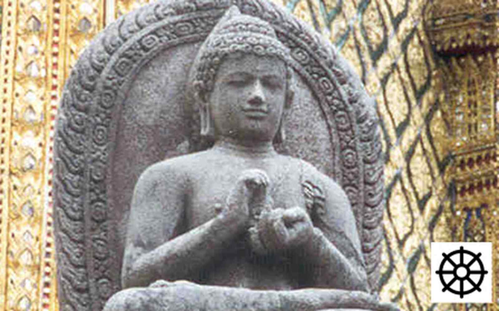 Statue of Buddha with Buddhist wheel symbol in corner 