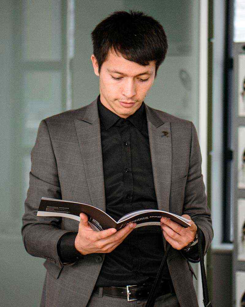 Business student looking at brochure, wearing suit 
