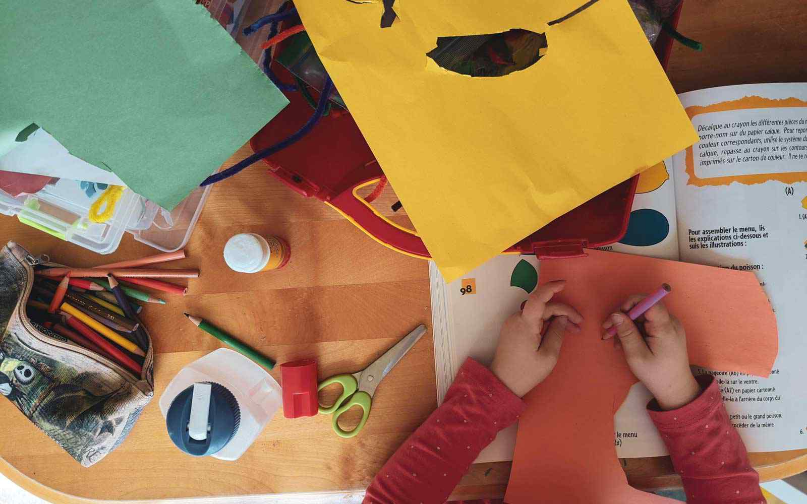 School child using coloured craft resources in school. 