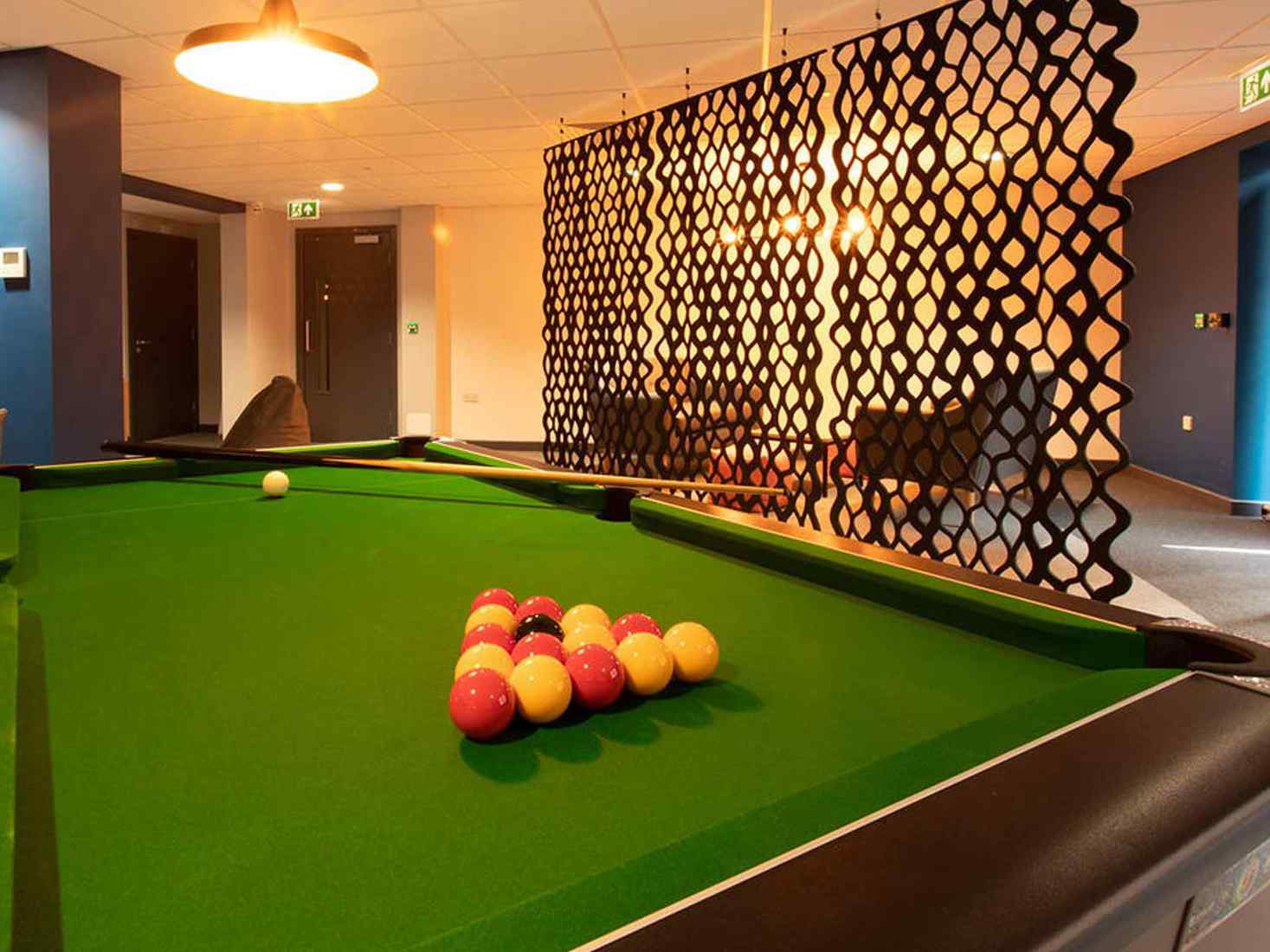 Common room with pool table in Abode accommodation site. 