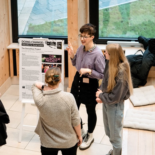 Researcher presenting poster at research event 