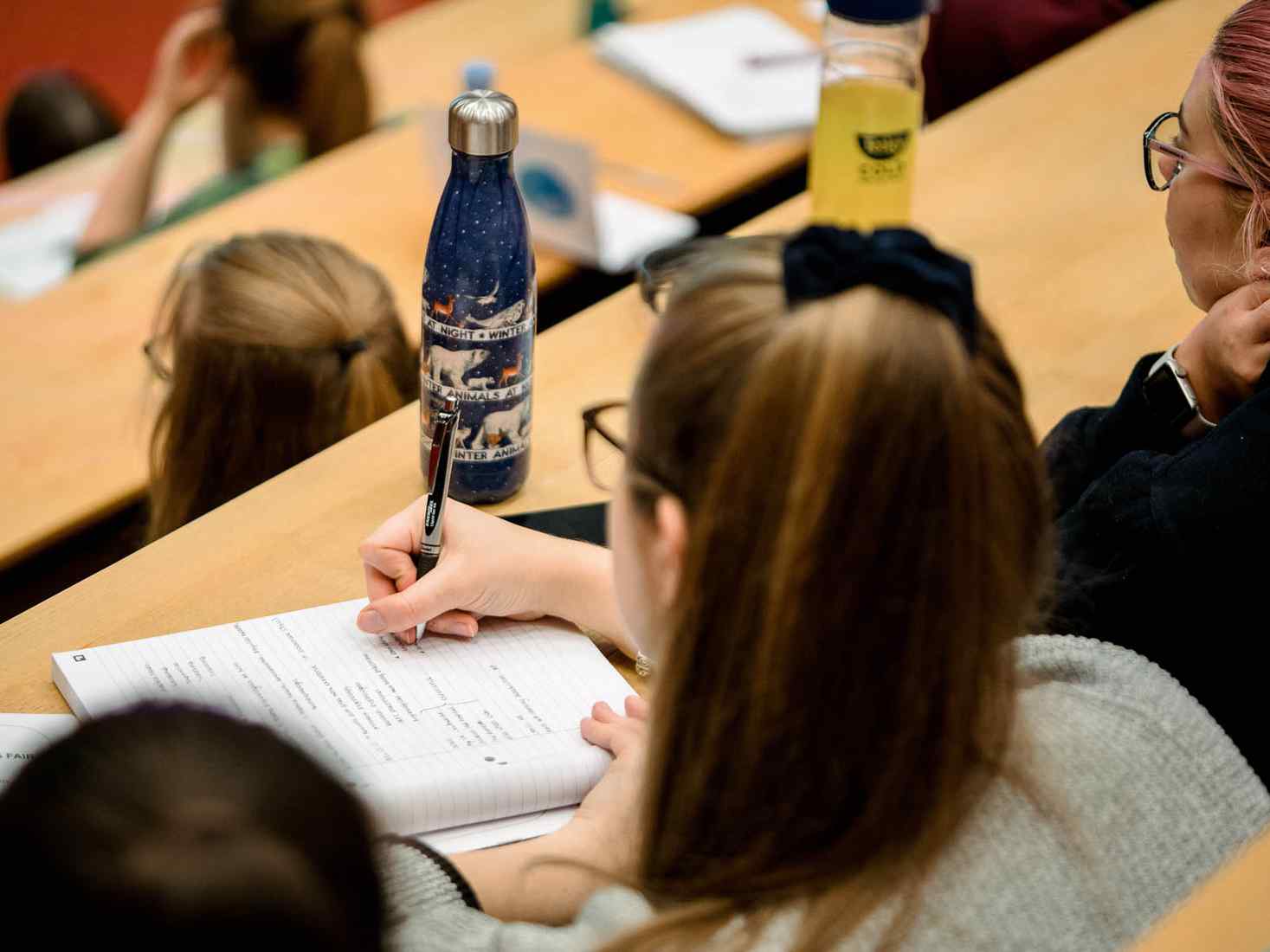 Student taking notes in lecture 