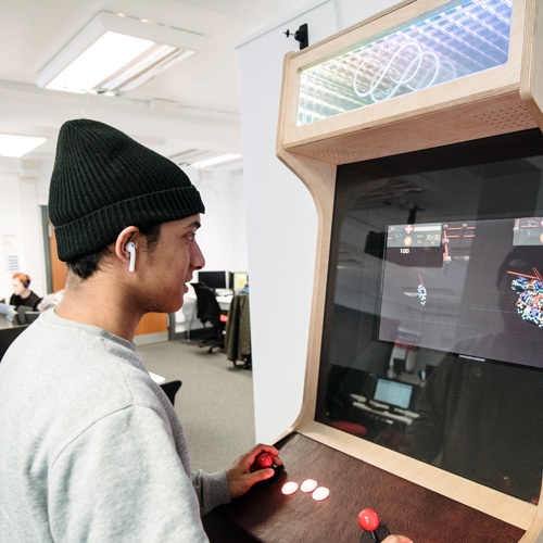 Student using games arcade machine 