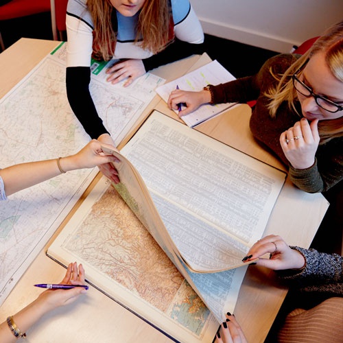 students looking at map on a desk 