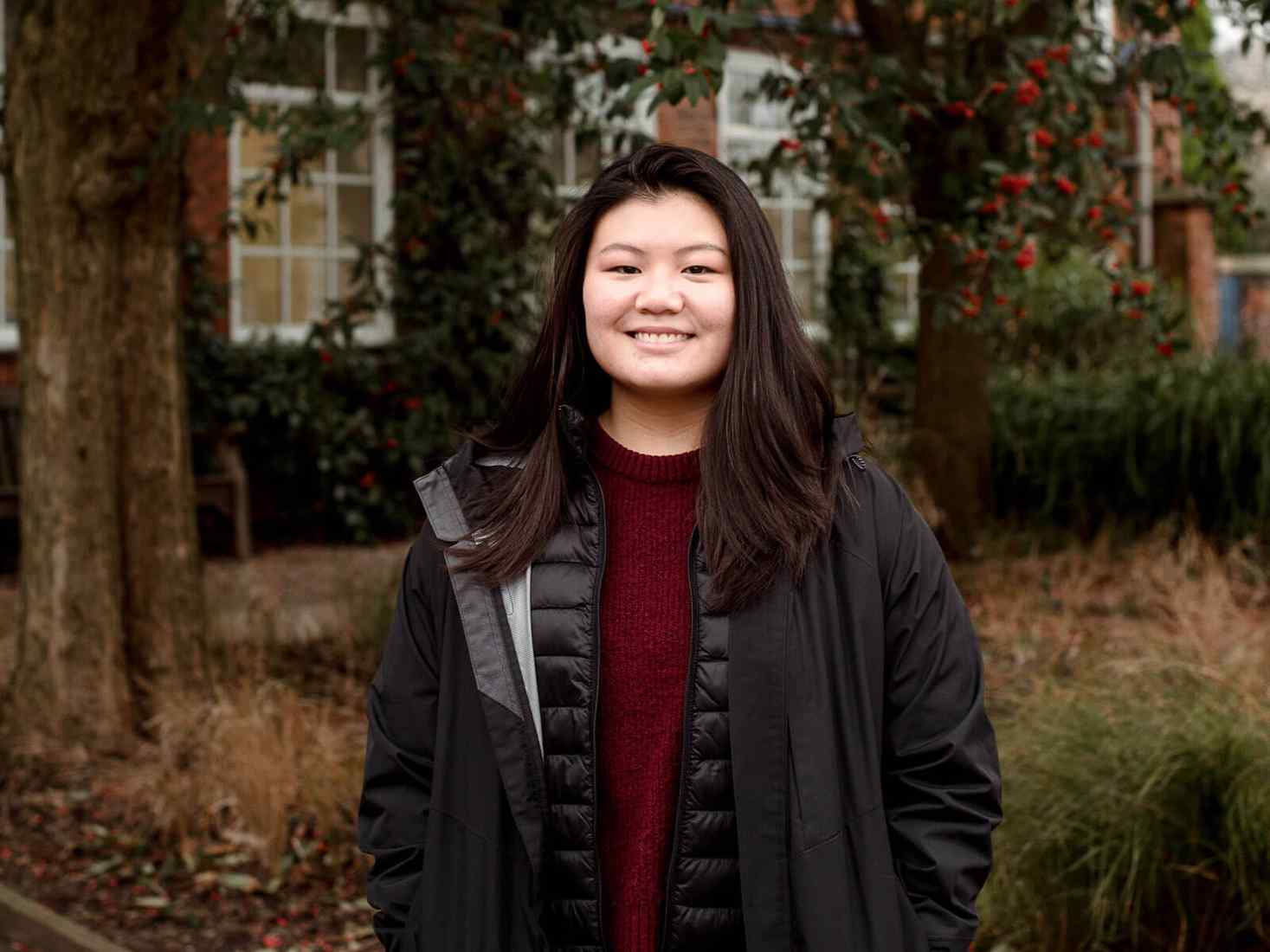 Student outside wearing coat and smiling 