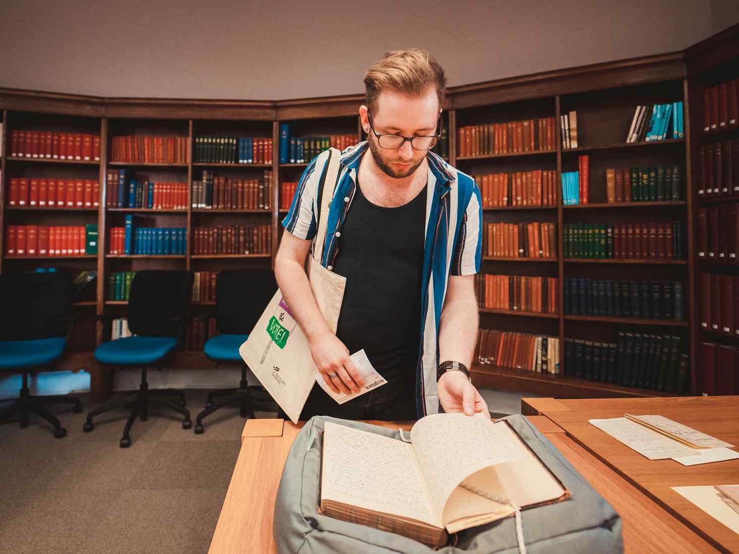 Student looking at historic book in library 