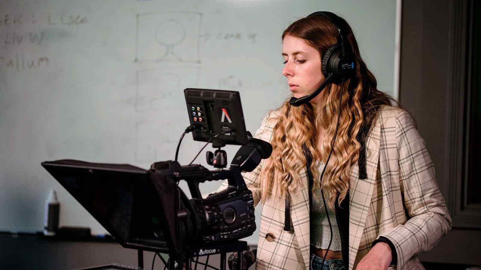 A media production student uses a camera. 