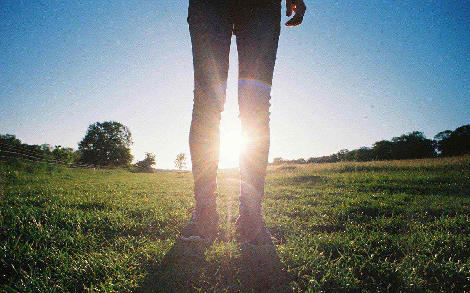 Legs with sunlight on a field 