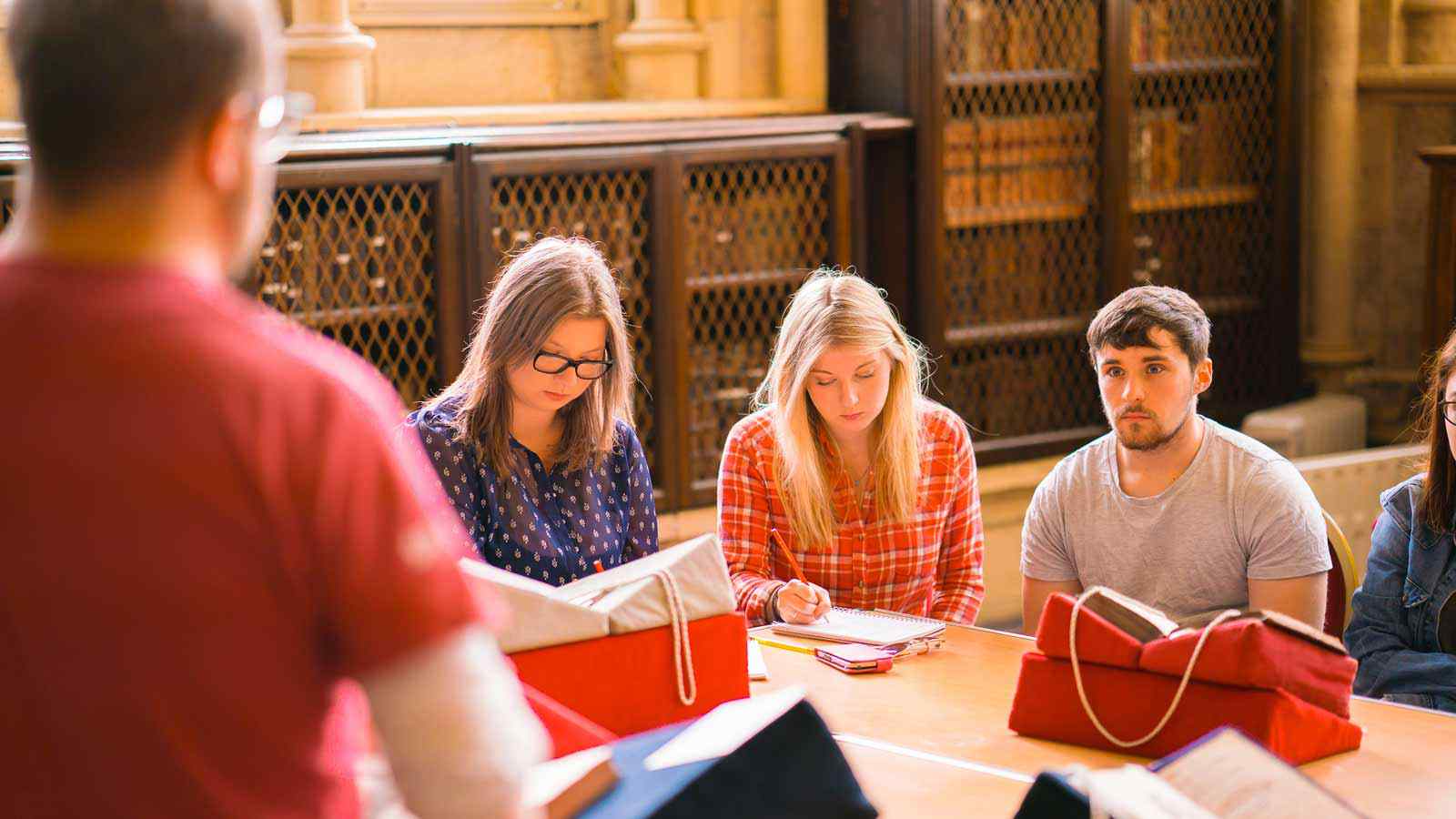 Three students work together in the York Minster library. 