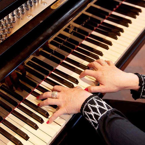 Overhead view of a person playing piano. 