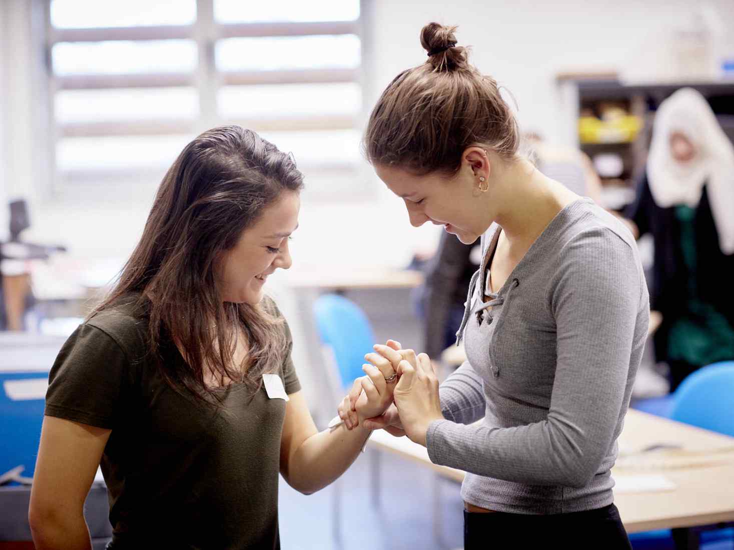 Student taking pulse of another student 