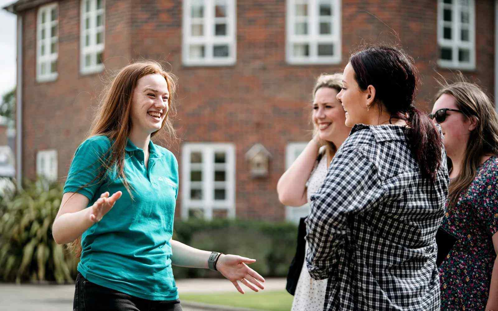A Student Ambassador talks to visitors at an Open Day. 
