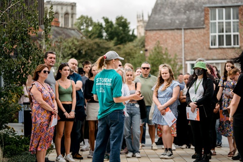 Student Ambassador leading large group of visitors on campus tour at Open Day 