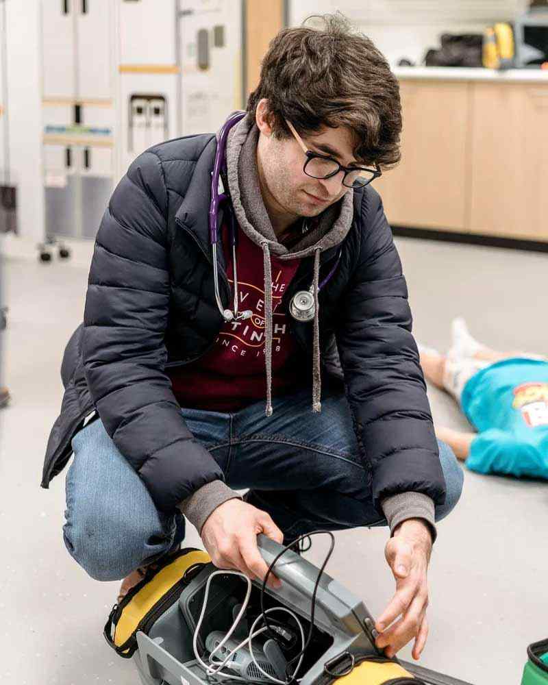 A student works with paramedic equipment. 