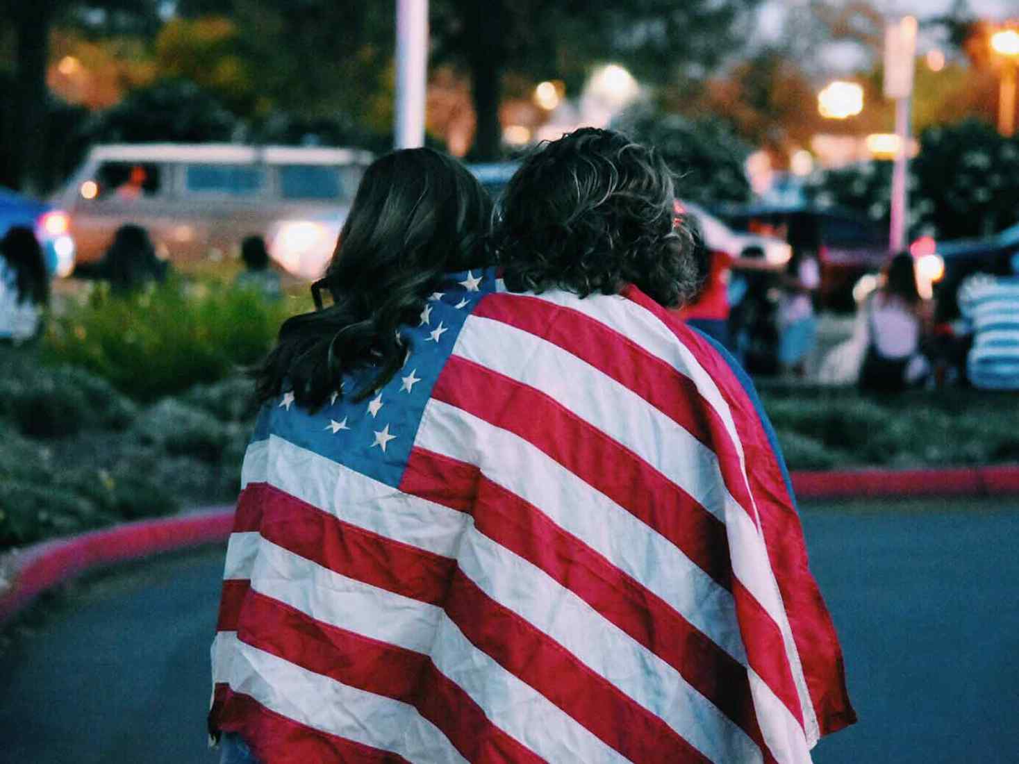 Two people stood wrapped in an american flag 