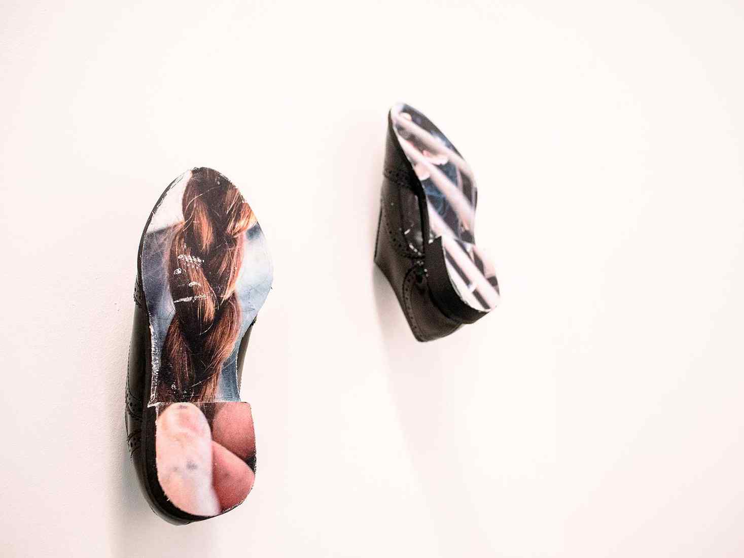 Two shoes on a wall in an exhibtion 