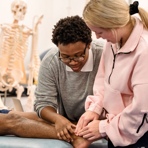 Student examining patient foot 