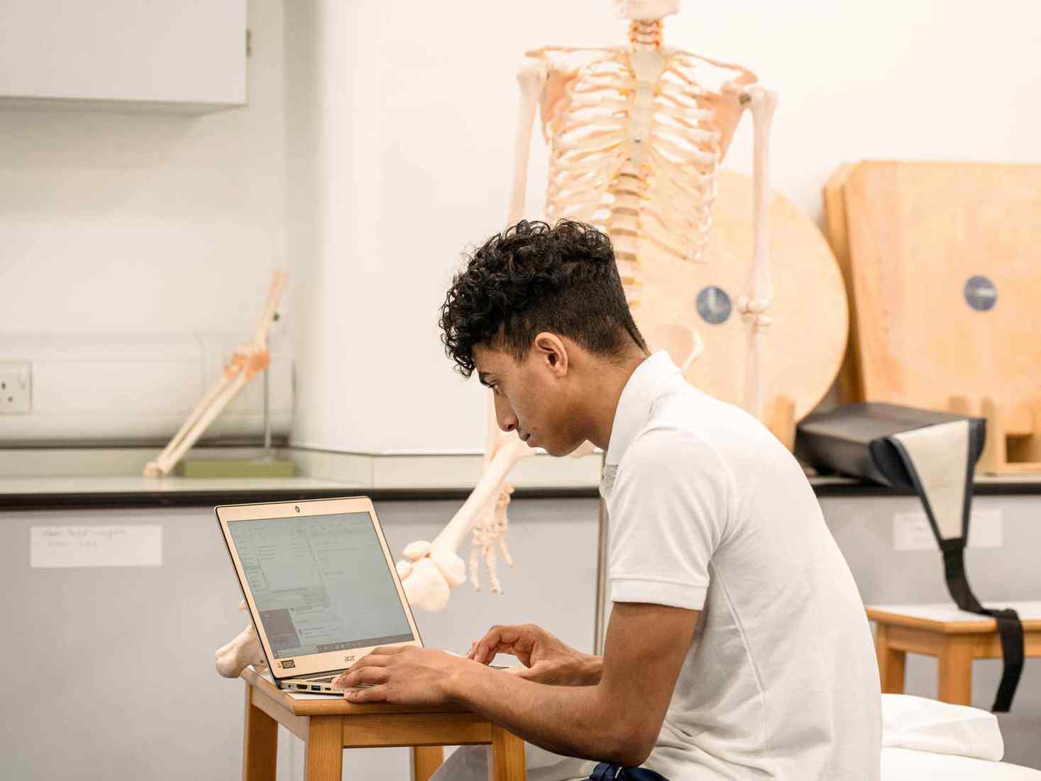 A student interacting with a skeleton 