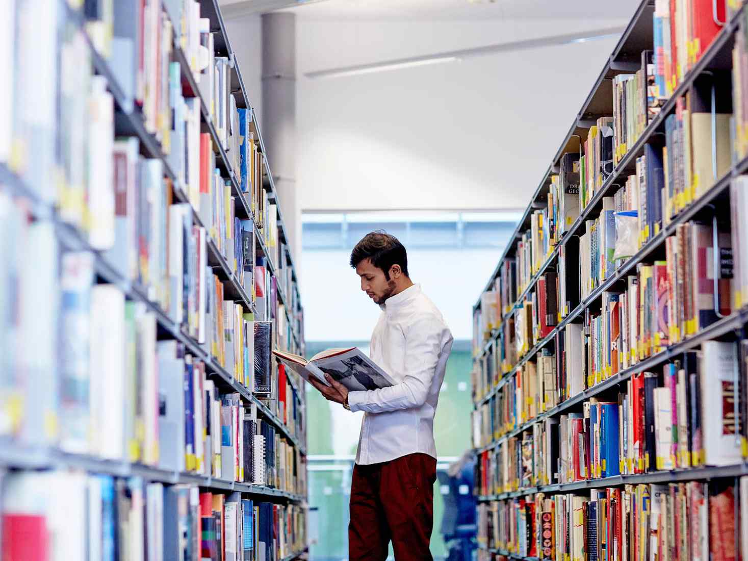 Student between shelves in library 