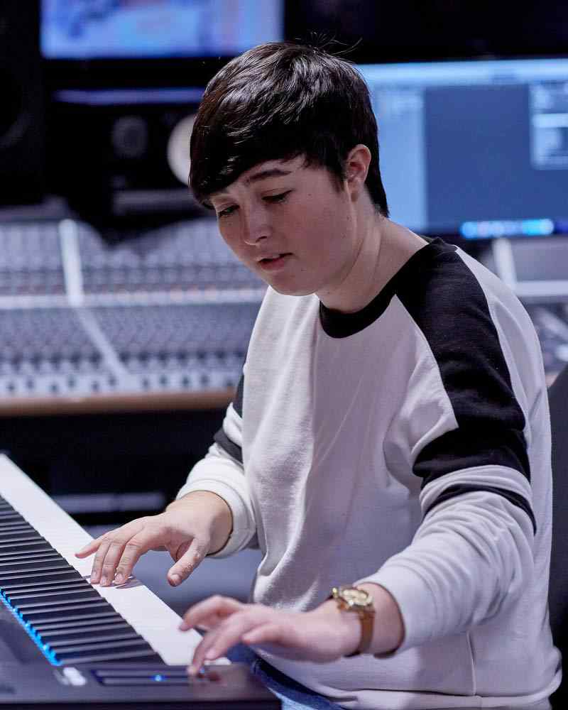 A music production student works at a keyboard. 