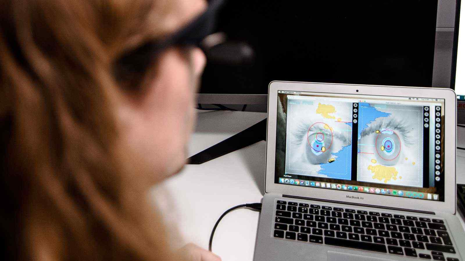 Psychology student tracking eye movements on laptop 