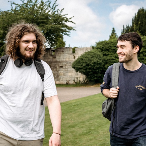Two students walking through Museum Gardens in York 