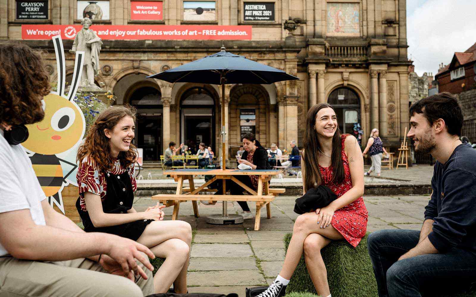 Four students talk together in the centre of York. 