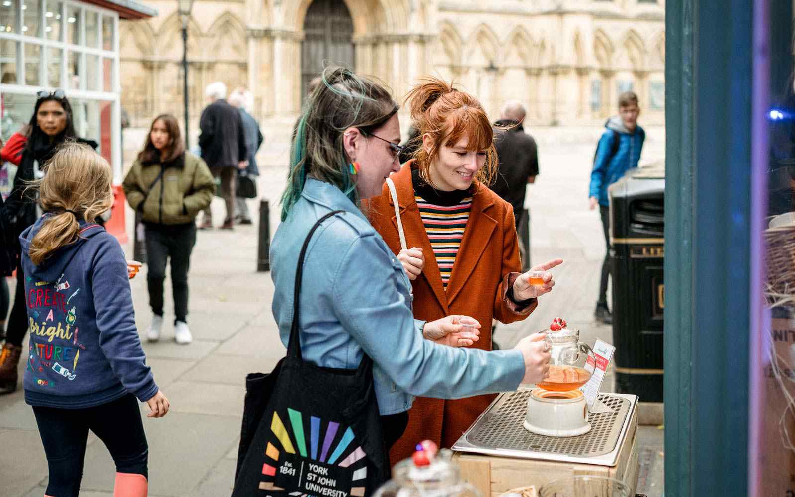 Two students pouring tea outside cafe in York 