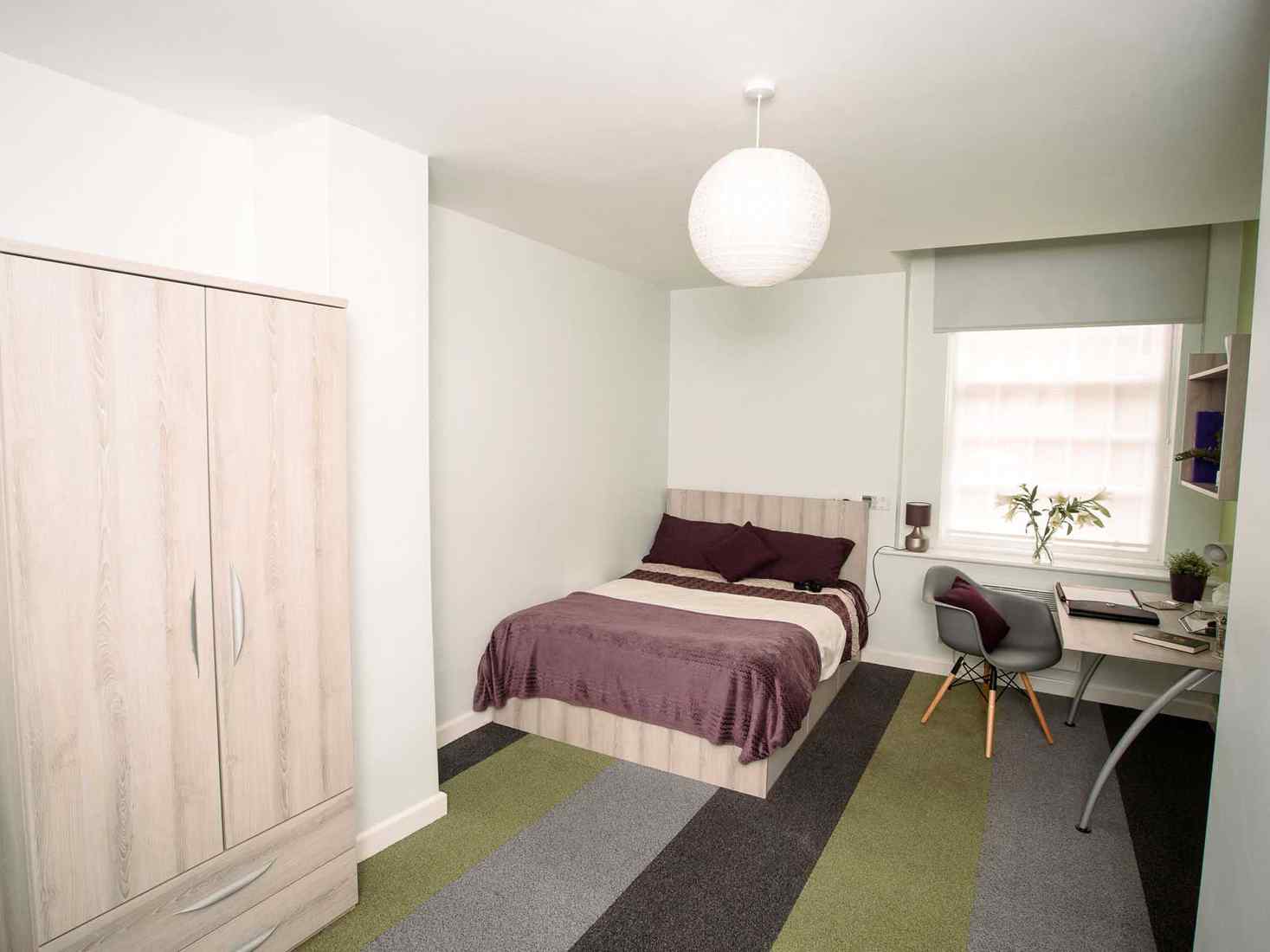 Student room with double bed, wardrobe and desk 