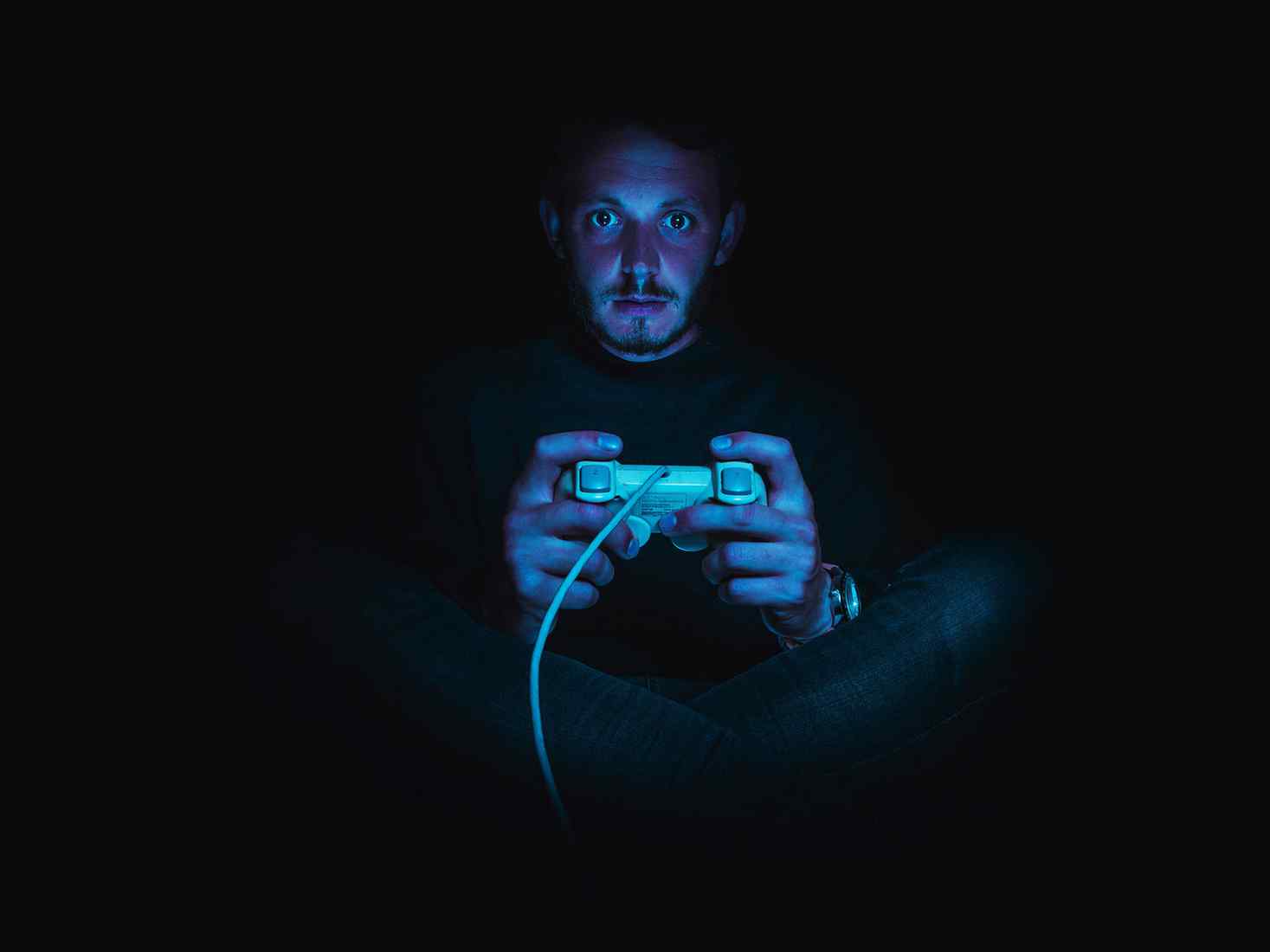 A person playing video games in low light 