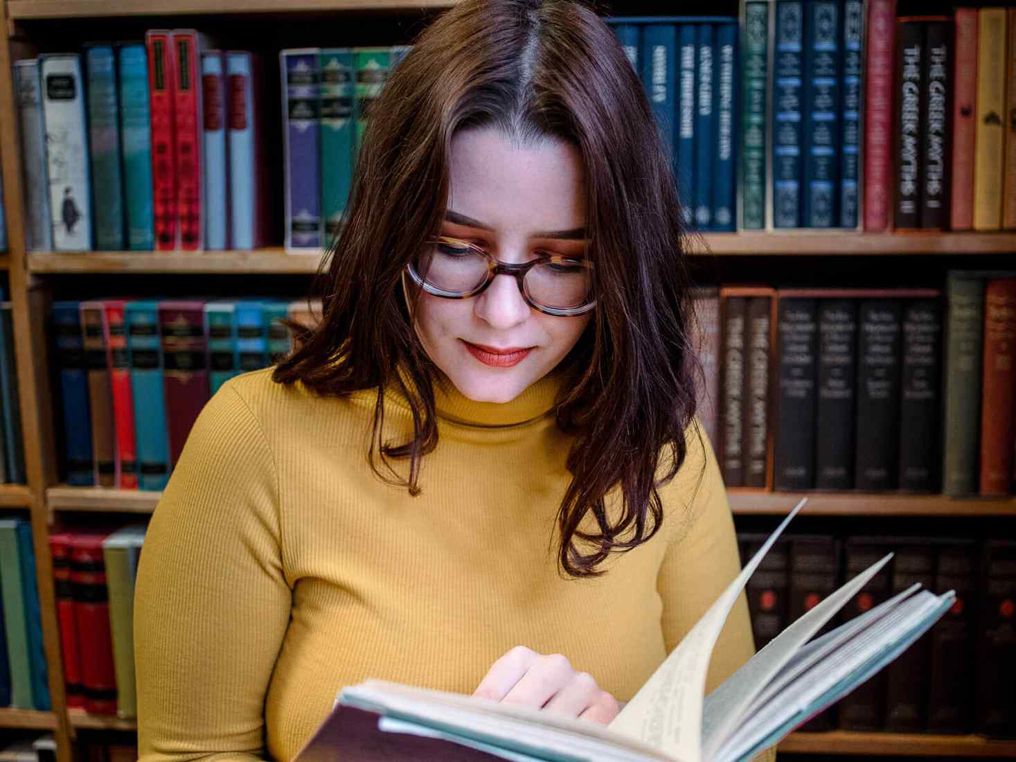 Student in library reading book 