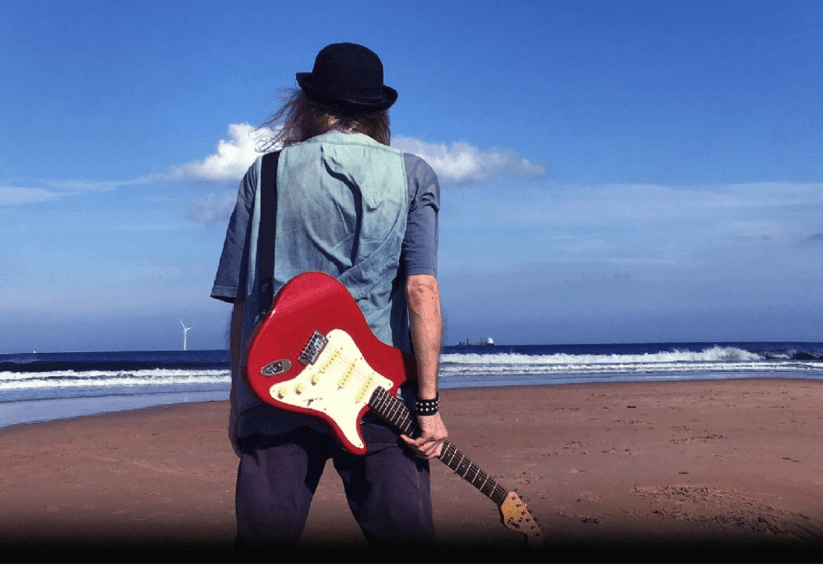 A guitarist on a beach 